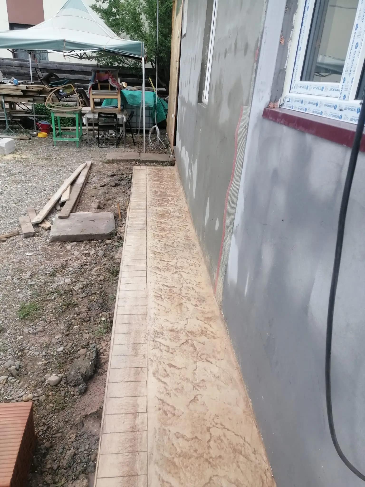 Alee laterală din beton amprentat crem bej lângă casă