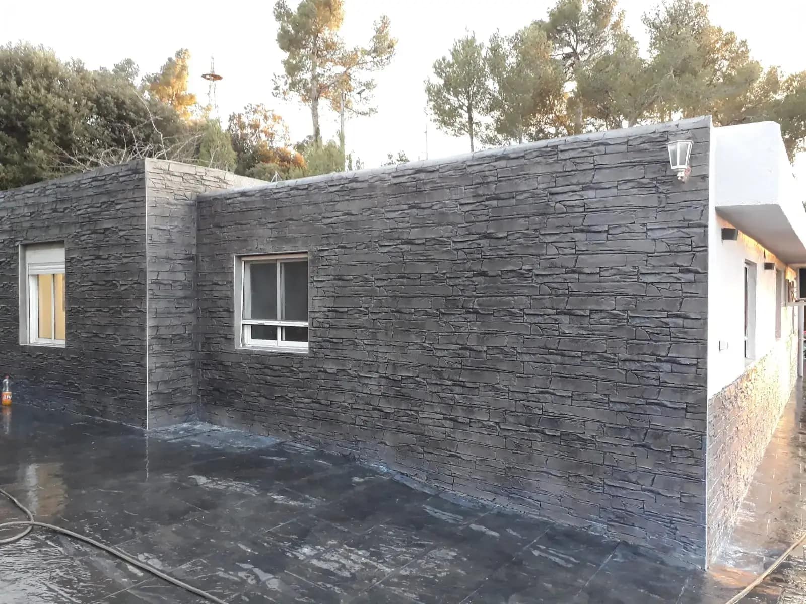Terasă beton amprentat grafit lângă perete decorativ din piatră
