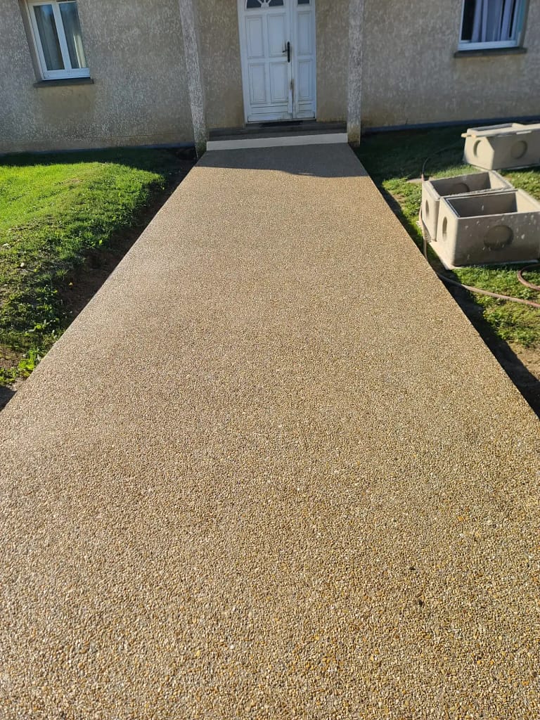 Acces intrare casă realizat din beton dezactivat cu finisaj durabil și elegant